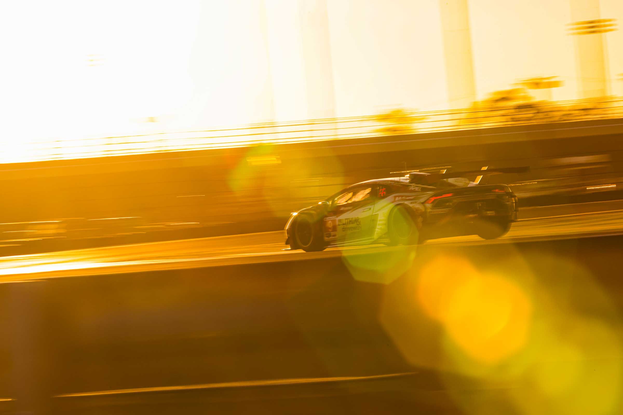 GT race car at speed in golden evening light
